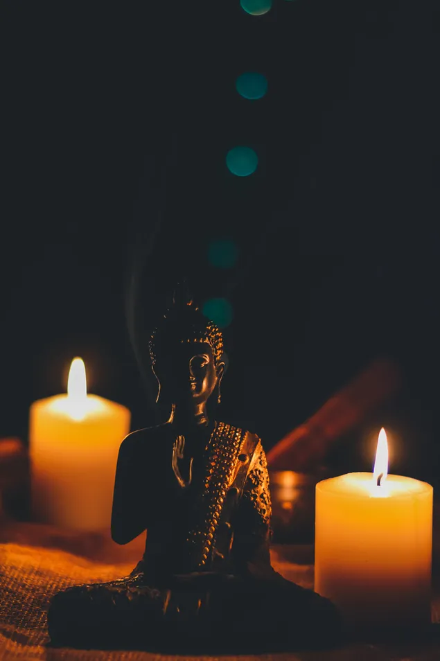 buddha duduk di samping lilin pilar unduhan