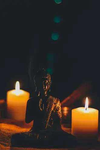 Tapeta Buddha sedí vedle sloupové svíčky 2K