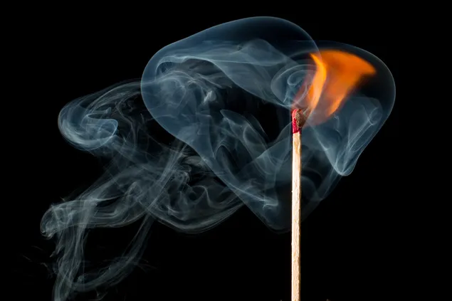 burning matchstick against a black background