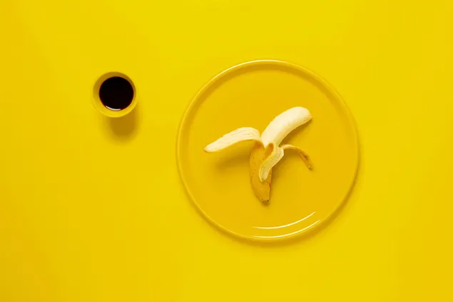 Café negro y plátano en fondo amarillo