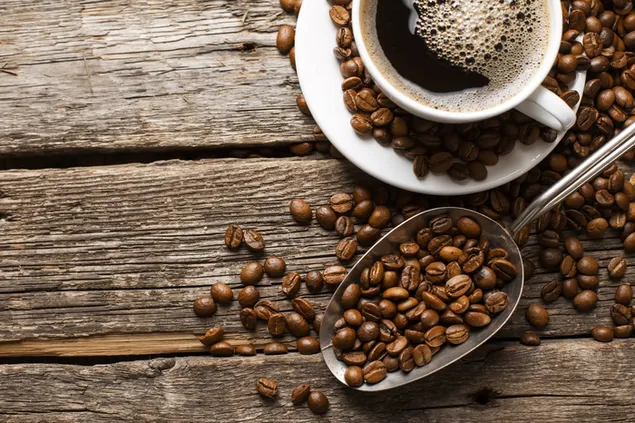 Café y granos de café en una taza de café en un piso de madera