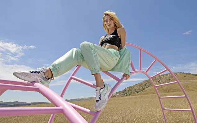 Cara Delevingne hanging out in a pink monkey bars with mountain background