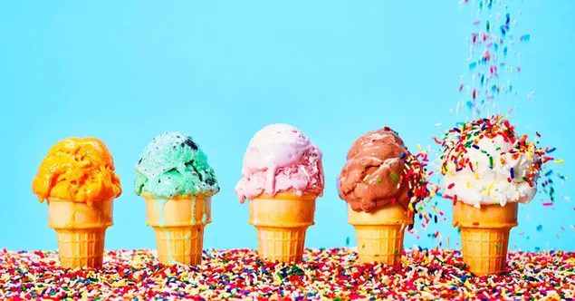 Caramelos coloridos vertidos en helado con varias frutas de todos los colores en conos