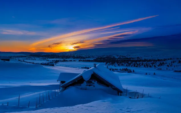 Casa cubierta de nieve en el campo de invierno