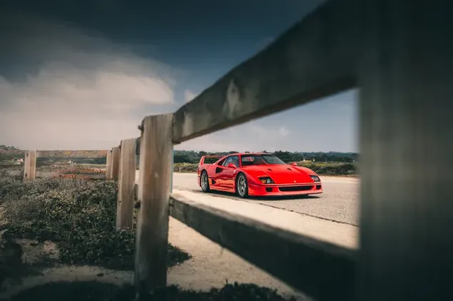 赤いスポーツカー フェラーリ f40 が雲のあるアスファルト道路に駐車、 ダウンロード