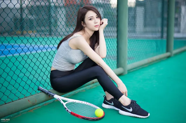 Chica asiática deportiva sexy jugando raqueta