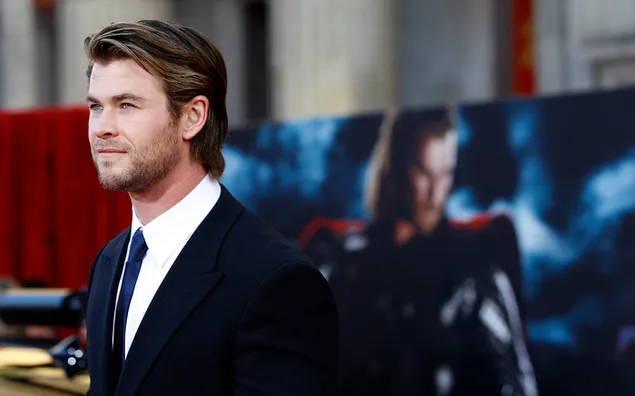 Aktor tampan Chris Hemsworth dalam setelan hitam dengan latar belakang formal 2K wallpaper
