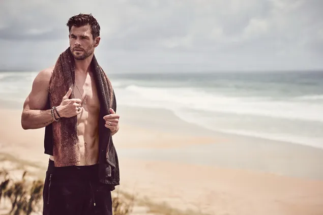 Chris Hemsworth, knappe acteur op het strand met zijn gespierde lichaam download