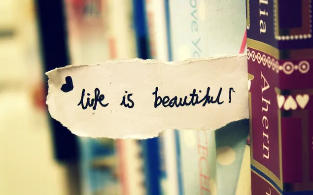 Cita "La vida es bella"; hay un pedazo de papel entre los libros que tiene forma de corazón