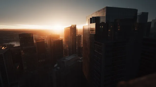 צללית של בנייני עיר על רקע אופק זוהר 2K טפט