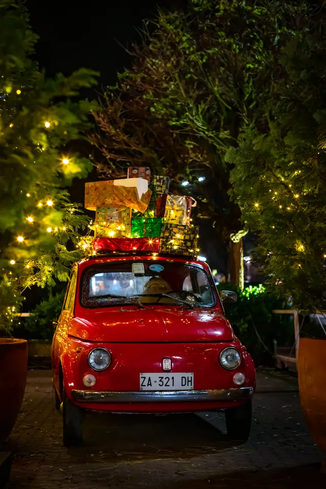 Klassischer roter FIAT 500 mit Weihnachtsboxen obendrauf herunterladen