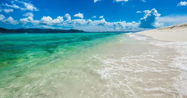 air laut yang jernih dan pantai yang bersih di musim panas di bawah langit berawan berwarna biru yang indah unduhan