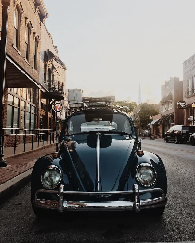 Nahaufnahmefoto des schwarzen Volkswagen Beetle in der Nähe des Gebäudes herunterladen