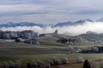 Het bewolkte landschap van Hirzel Zwitserland en mistige bergen 6K achtergrond