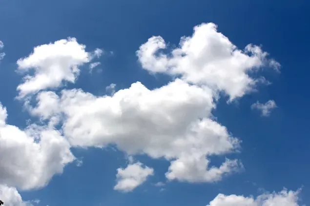 Clusters van witte wolken verzamelden zich in de blauwe lucht
