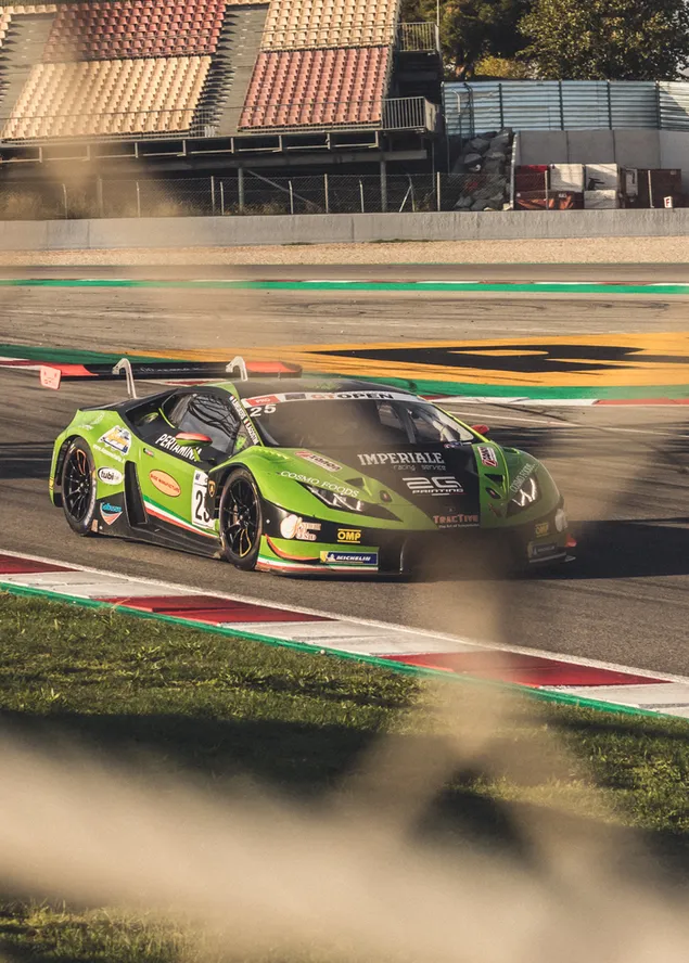 Coche de carreras Lamborghini verde y negro en la pista durante el día