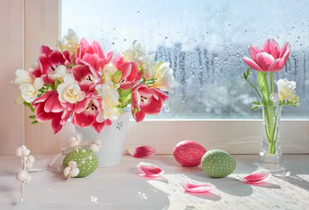 Bunte Blumen und bunte Ostereier in einer Vase vor dem Fenster mit Regentropfen herunterladen
