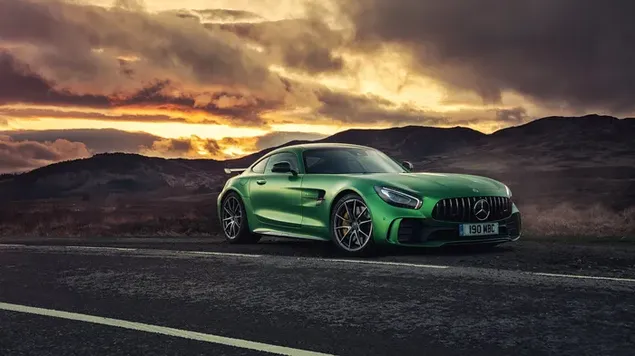 Cool Mercedes in green color parked on the road in view of clouds reflecting yellow rays of sun