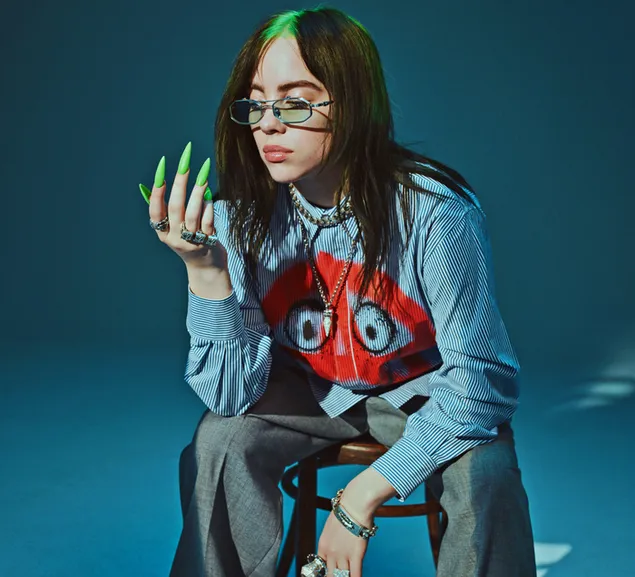Cool singer Billie Eilish sitting in a stool with blue background