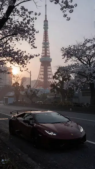 crimson lamborghini huracan beneath tokyo tower and cherry blossoms at sunrise download