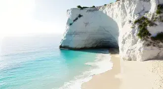 crystal-clear turquoise waves gently lap against pristine white cliffs and soft sandy shores, creating a peaceful seaside paradise download
