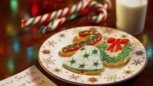 Delicias navideñas como galletas, dulces en plato y leche.