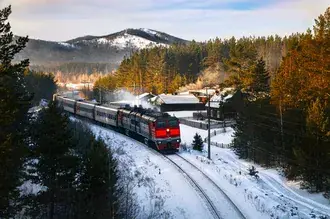 Tapeta Odjezd vlaku z červeného nádraží pohybujícího se po železnici mezi zasněženými horami a lesy HD