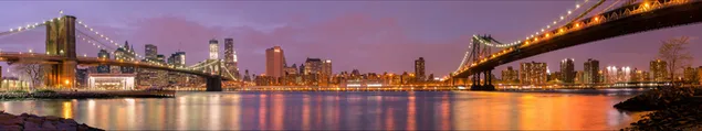 Die Lichter der Brooklyn Bridge und der Manhattan Bridge und die Farben der Lichter der Stadt, die sich im Meer spiegeln
