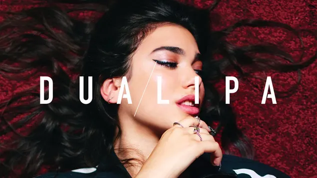 Dua lipa acostada boca arriba con las manos debajo de la barbilla con cabello oscuro desordenado HD fondo de pantalla