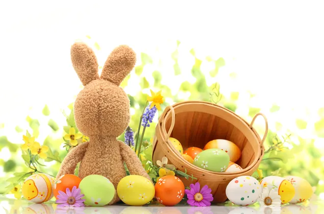 Conejo marrón de Pascua y huevos pintados de colores en un balde con fondo de flores 4K fondo de pantalla