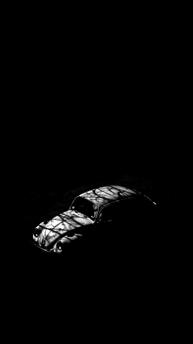 Een vintage auto met witte lichten en schaduwen die vormen vormen op een zwarte achtergrond