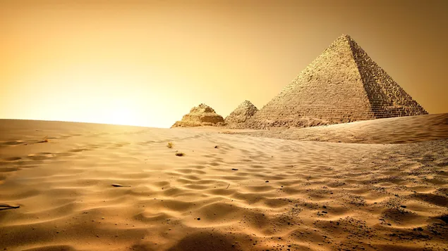 Piramida Mesir di atas pasir gurun di bawah sinar matahari dengan warna kuning 4K wallpaper