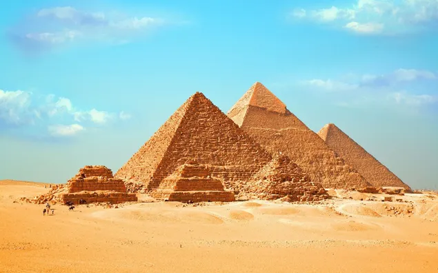 Piramida Mesir, manusia dan unta di gurun pasir di bawah sinar matahari dalam cuaca mendung 2K wallpaper