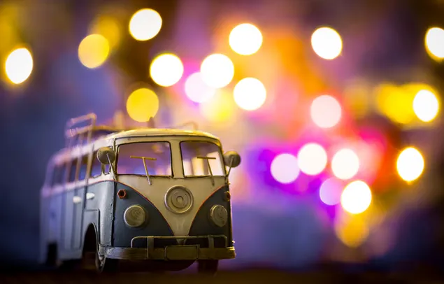 Ein klassisches Volkswagen-Spielzeugauto vor farbigen verschwommenen Lichtern
