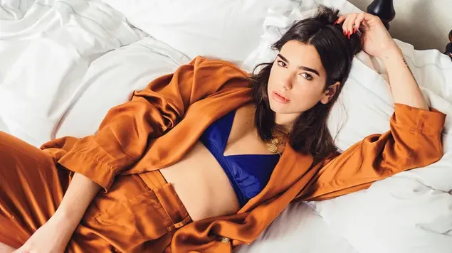 Engelse singer-songwriter Dua Lipa draagt ​​een oranje zijdeachtige pyjama