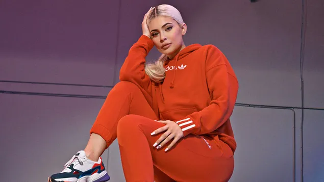 Taustpilt Kuulus meediategelane blond Kylie Jenner, kes kannab oranži värvi sobivaid Adidaseid 4K