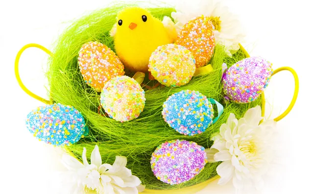 Farbige Eier und gelbe Küken im Korb