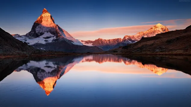 fassinerende kleure van die meer wat in die sneeuberge en landskap weerspieel word aflaai