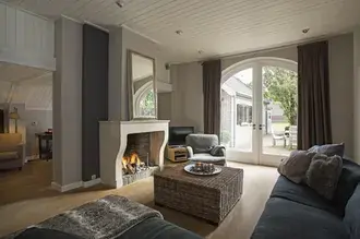 fireplace with sofa, mirror, table and armchair