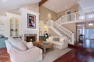 fireplace with sofa, table, painting, and stairs