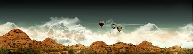Fliegende Ballons, die über dichten weißen Wolken und Bergen fliegen