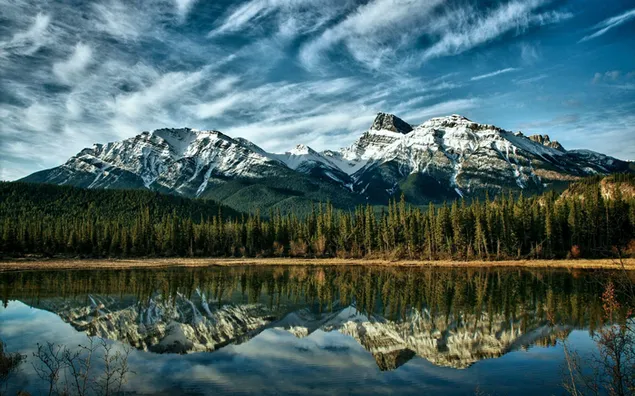 Bosques y montañas rocosas canadienses nevadas reflejadas en el lago 2K fondo de pantalla