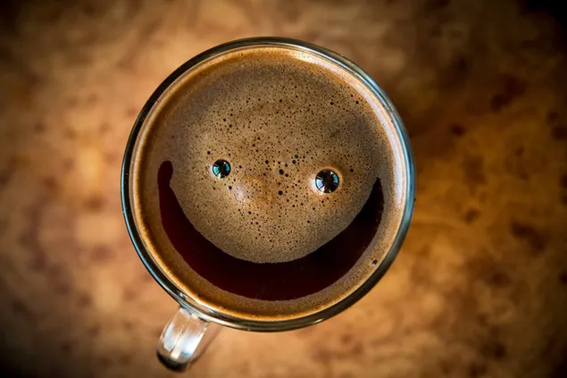 Un deliciós cafè espumós amb un patró somrient baixada