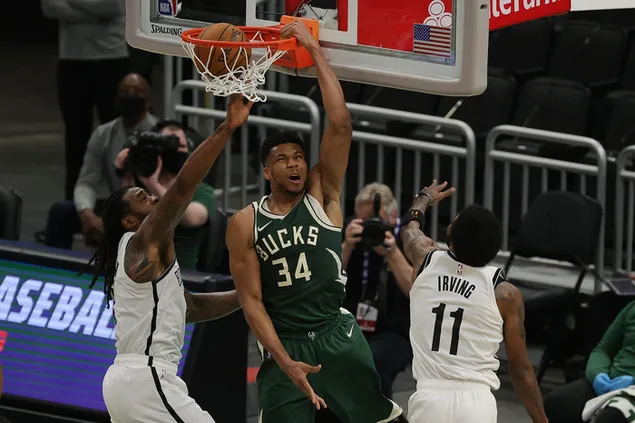 Giannis antetokounmpo dunks between two players