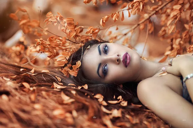 Chica en hojas de otoño