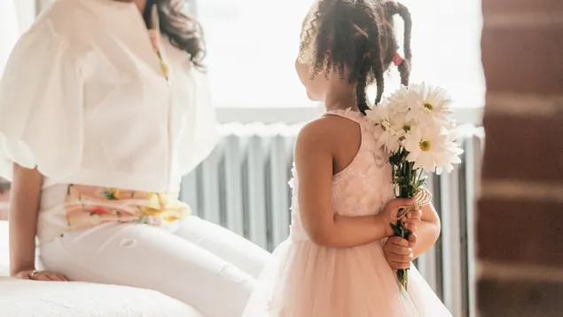 Mergina rožine suknele, už savęs slepianti gėles, švenčia motinos dieną 4K ekrano užsklanda