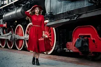 Tapeta Dívka v červených šatech drží kufr v rukou vedle vintage vlaku HD
