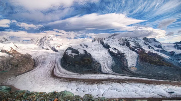 流れる雲と雪に覆われた山頂の氷河の景色