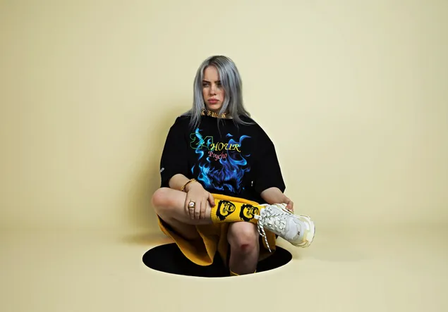 Gray haired Billie Eilish sitting in a whole 