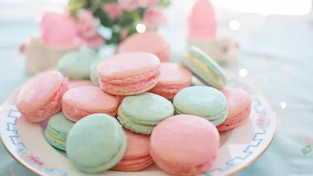 Macarons verdi e rosa serviti su un piatto su uno sfondo sfocato 4K sfondo